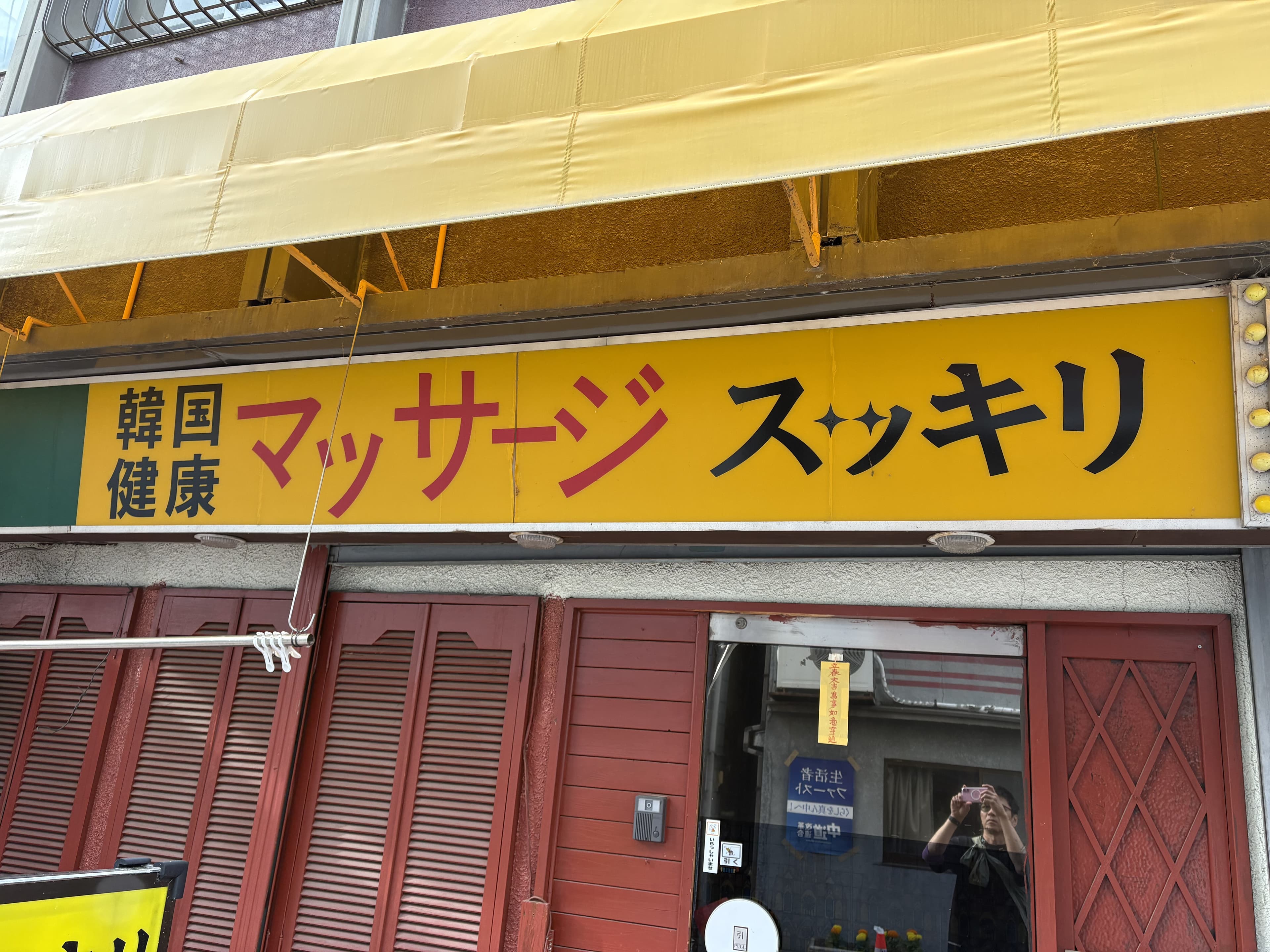 上田市中心部の黄色い面板に残る「スッキリ」の健康マッサージ看板
