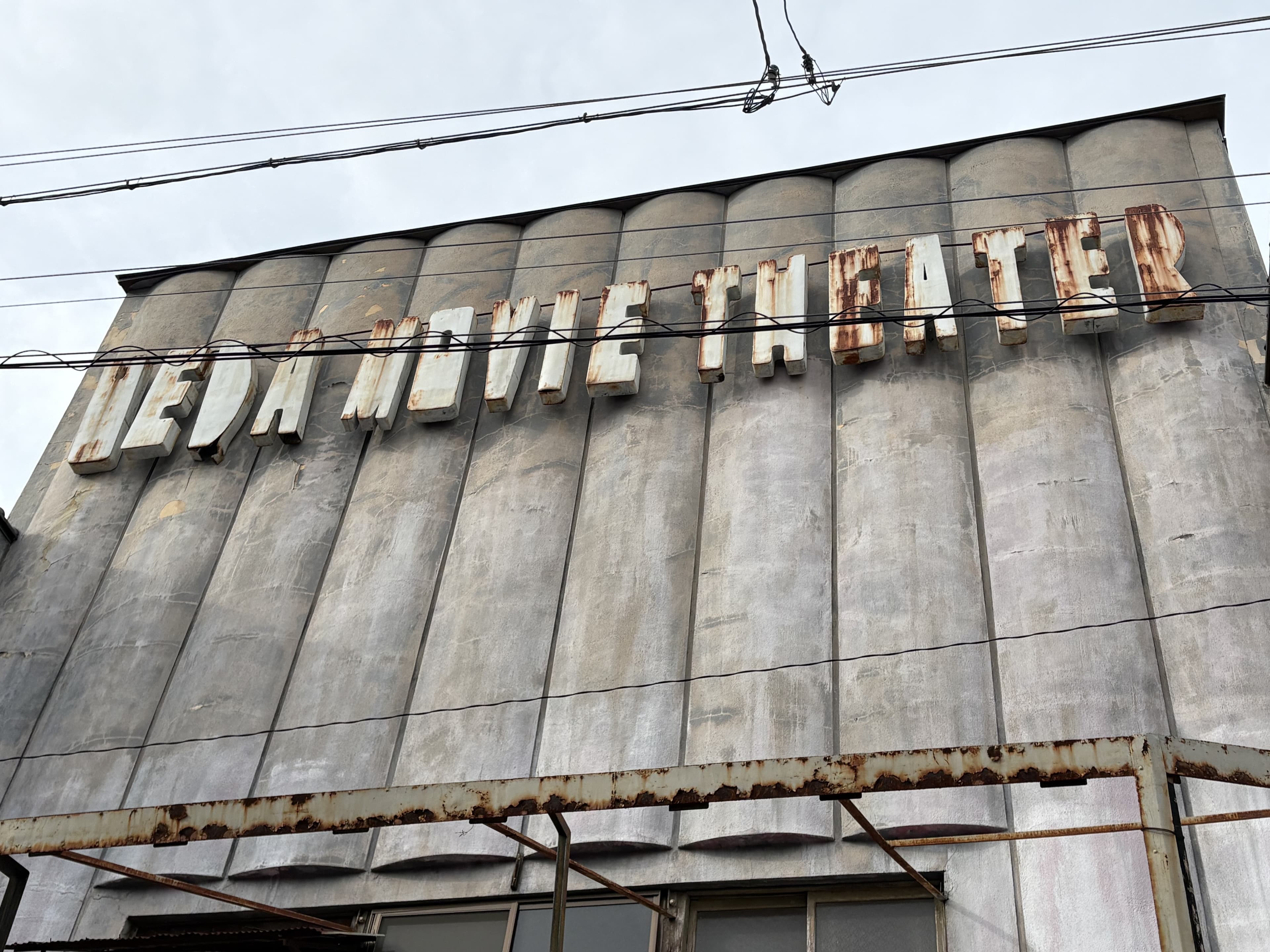 上田市中心部の外壁に浮かぶ「UEDA MOVIE THEATER」の古い英字看板