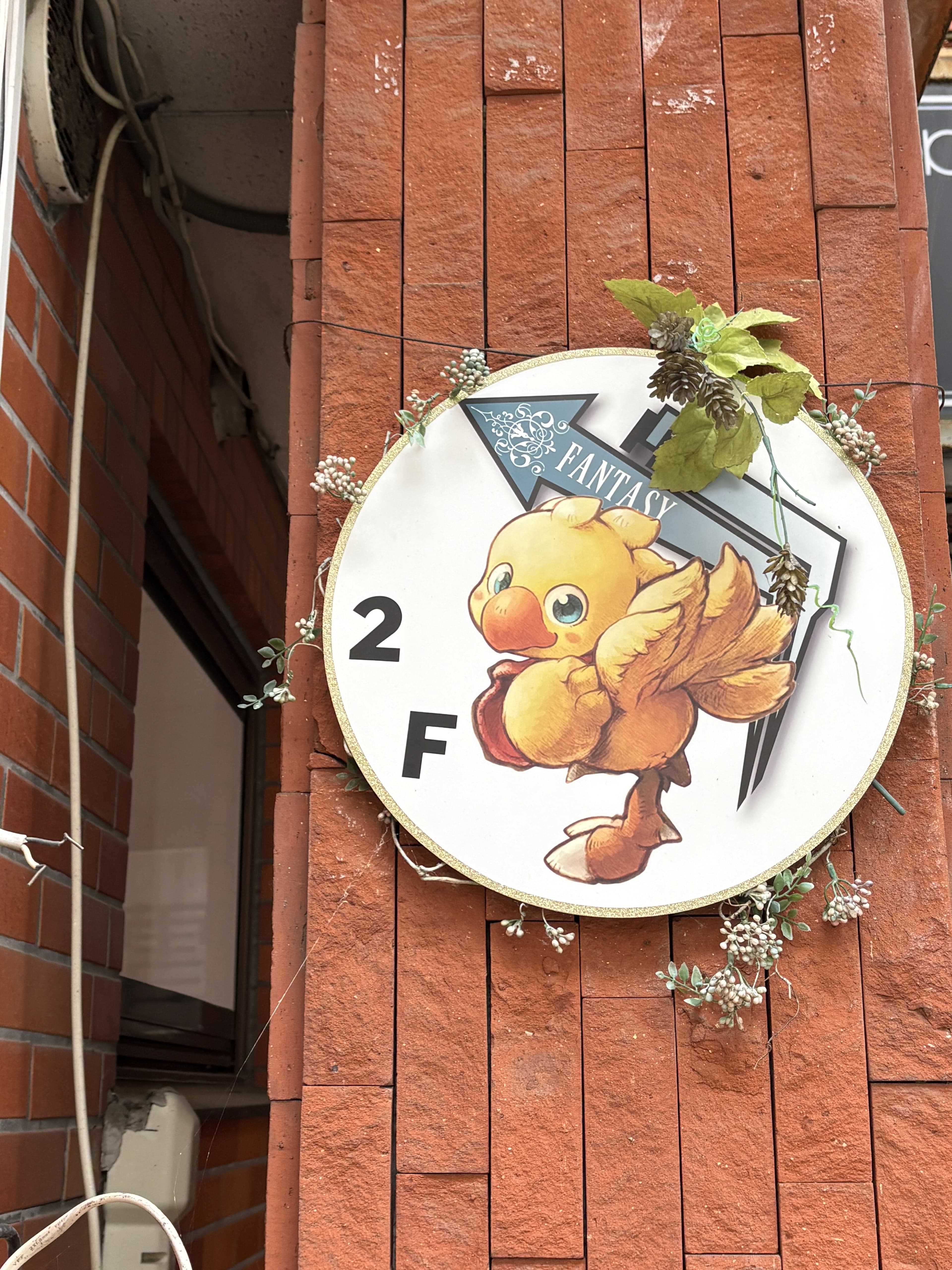 ひよこのイラストを添えた丸い「FANTASY」2階看板