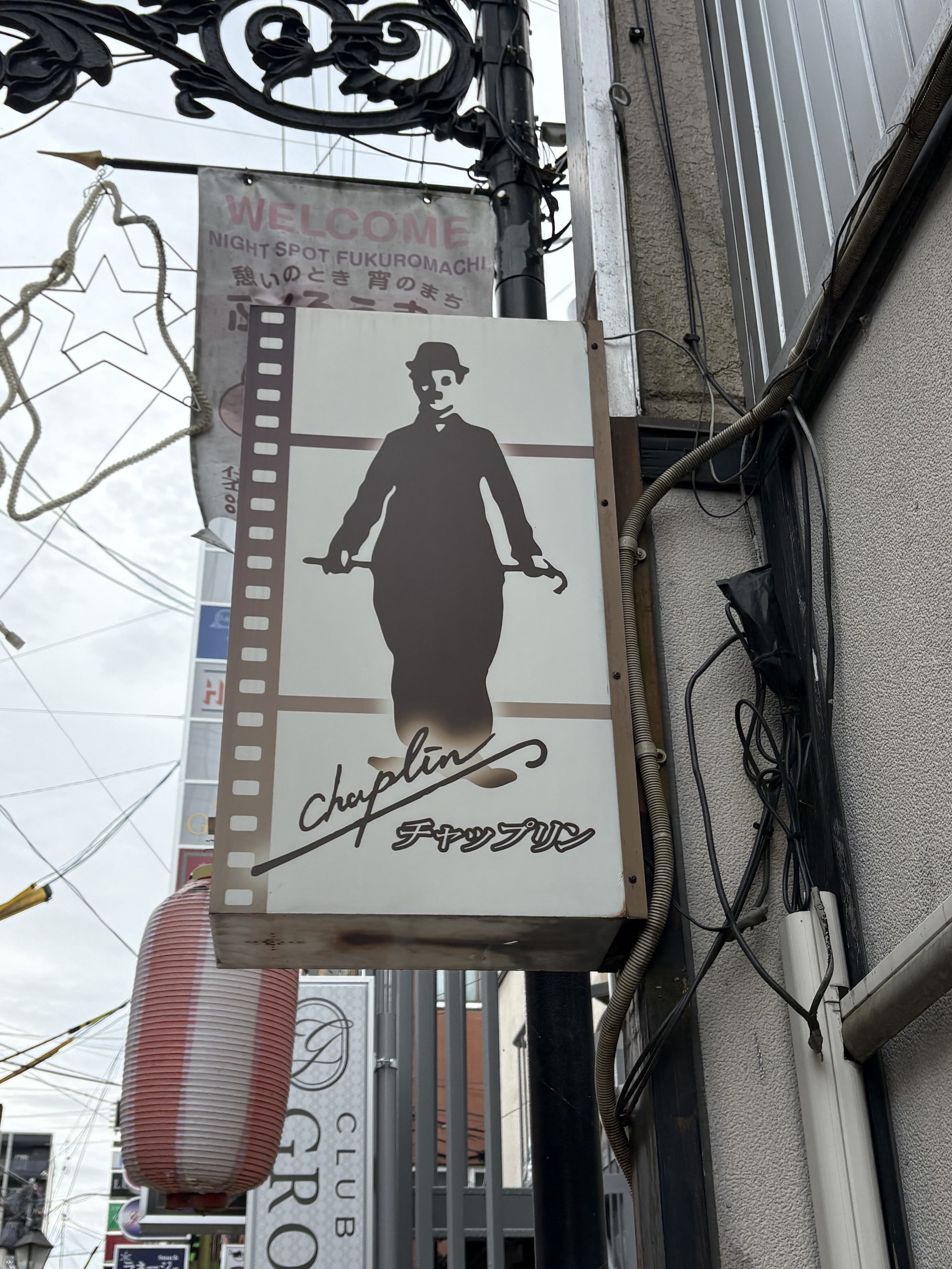 映画フィルムと人影を描いた「チャップリン」看板