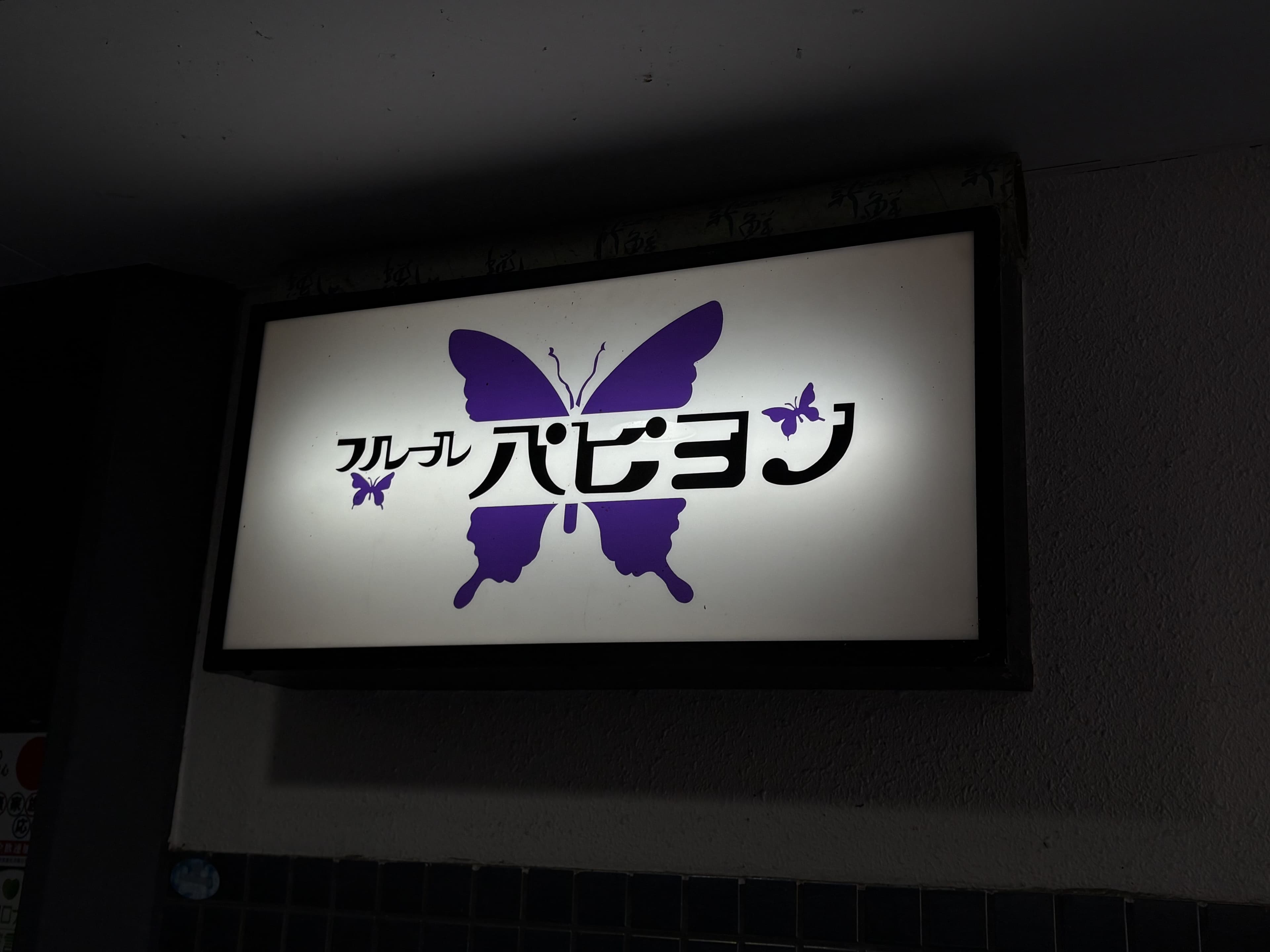 紫の蝶を大きく描いた「フルフル ハピョン」看板