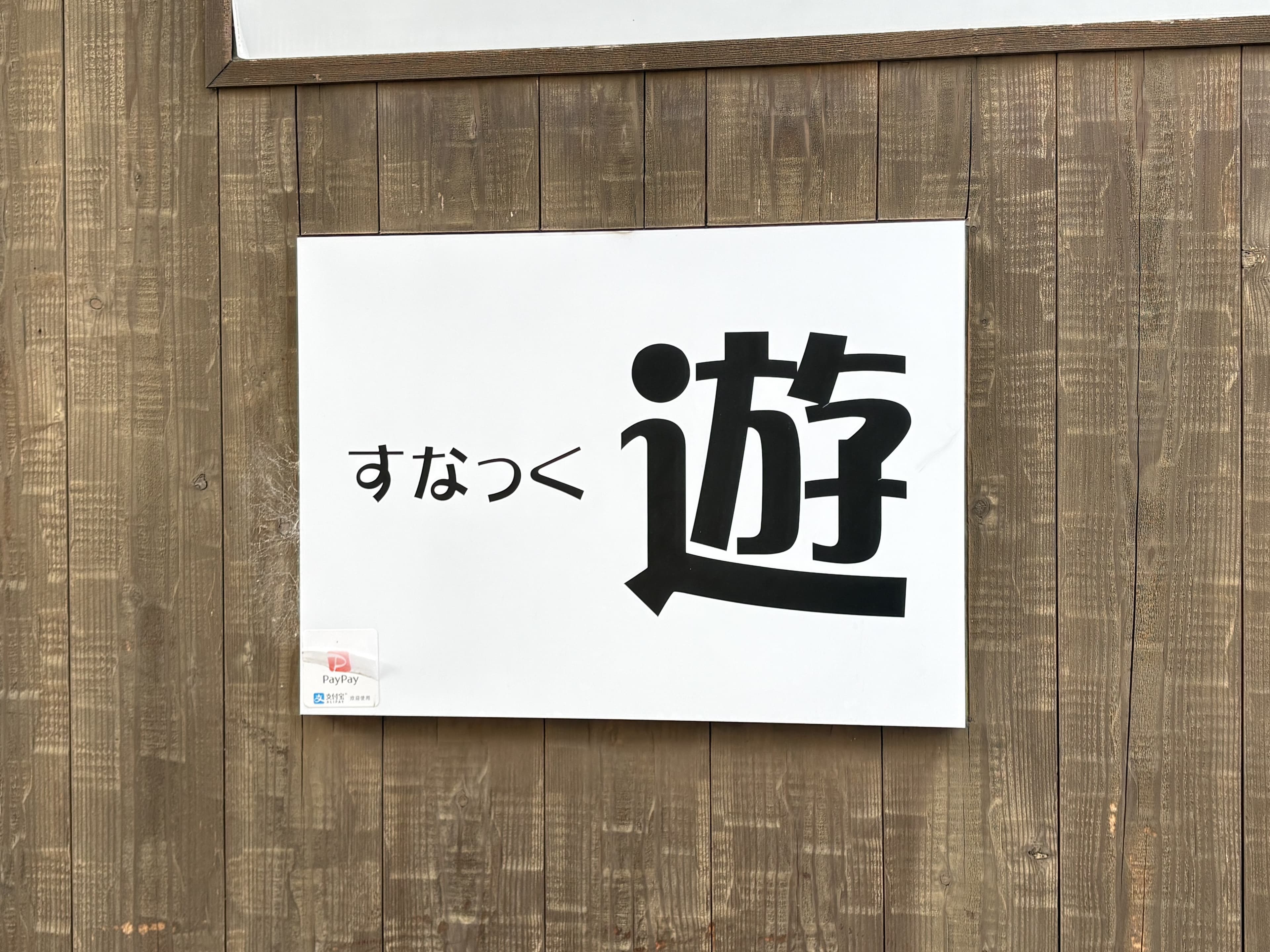 白地に大きな一文字を置いた「すなっく 遊」看板