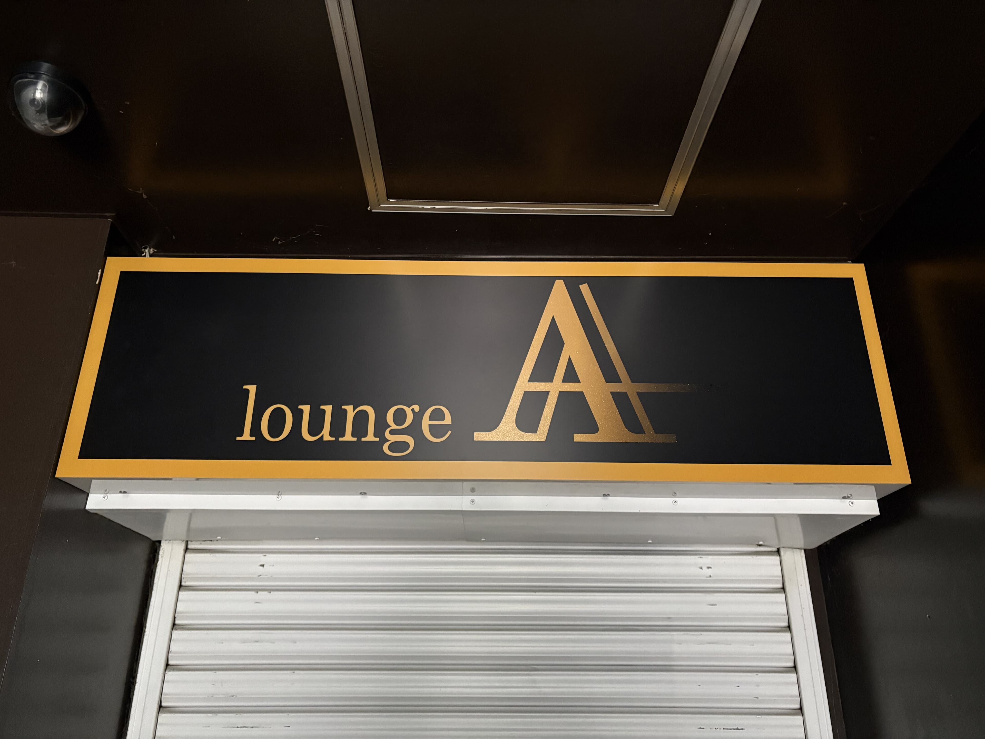 黄色い文字の「lounge A」シャッター上看板