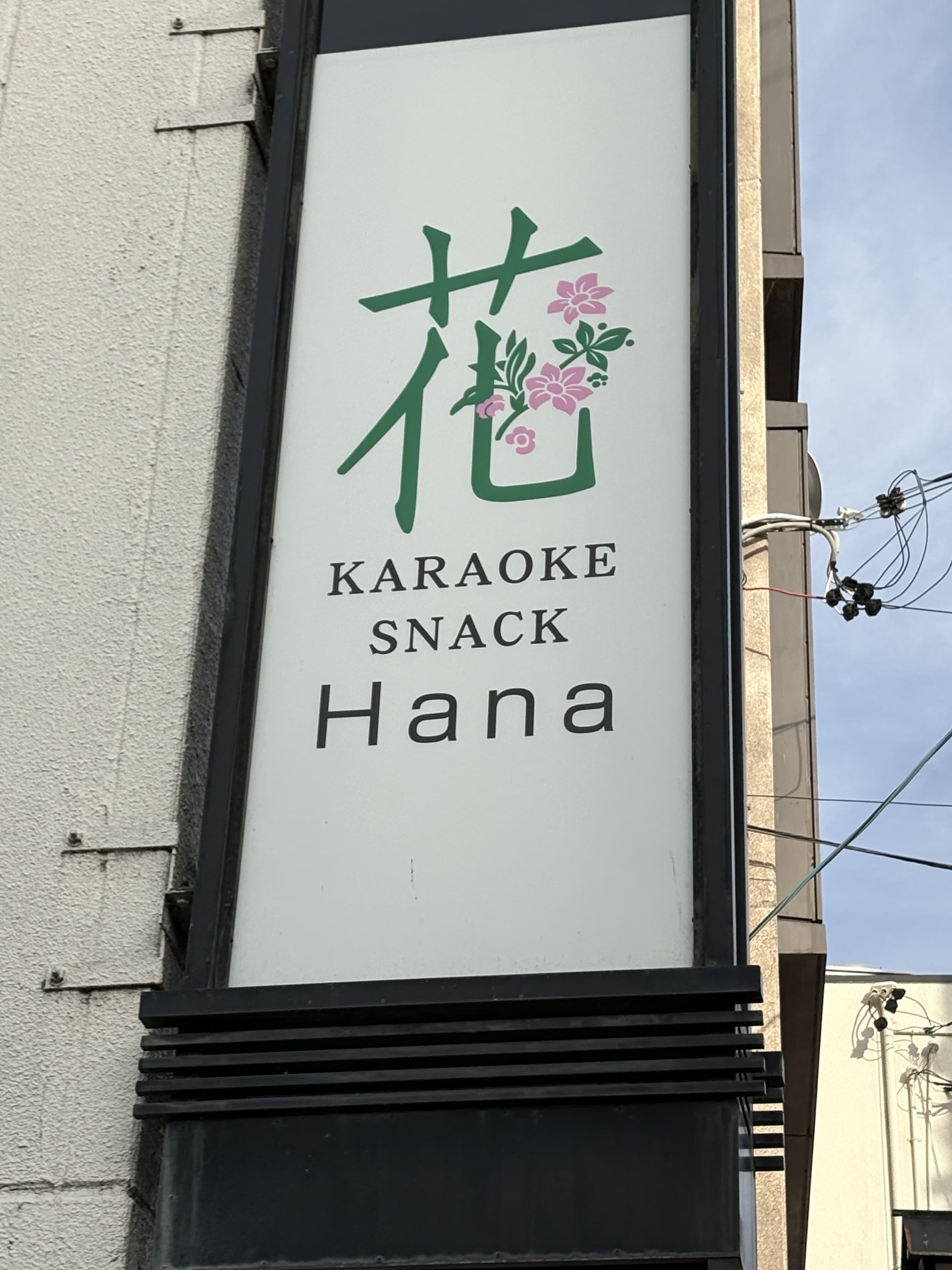 白い縦型看板「花 KARAOKE SNACK Hana」