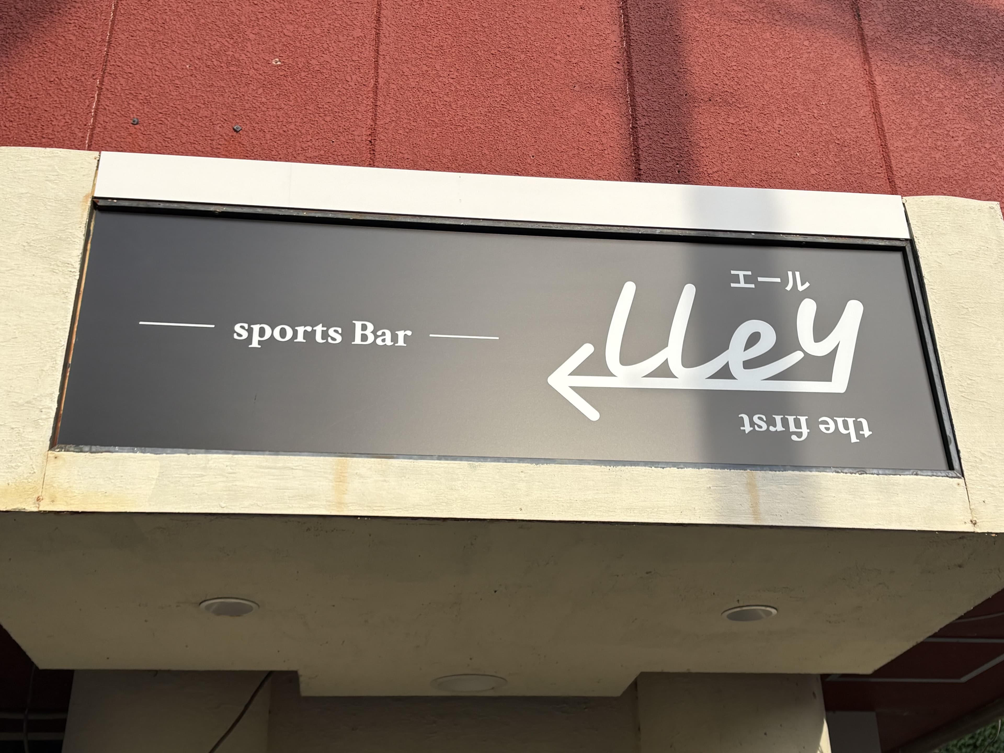 黒い横長看板「sports Bar Alley the first」