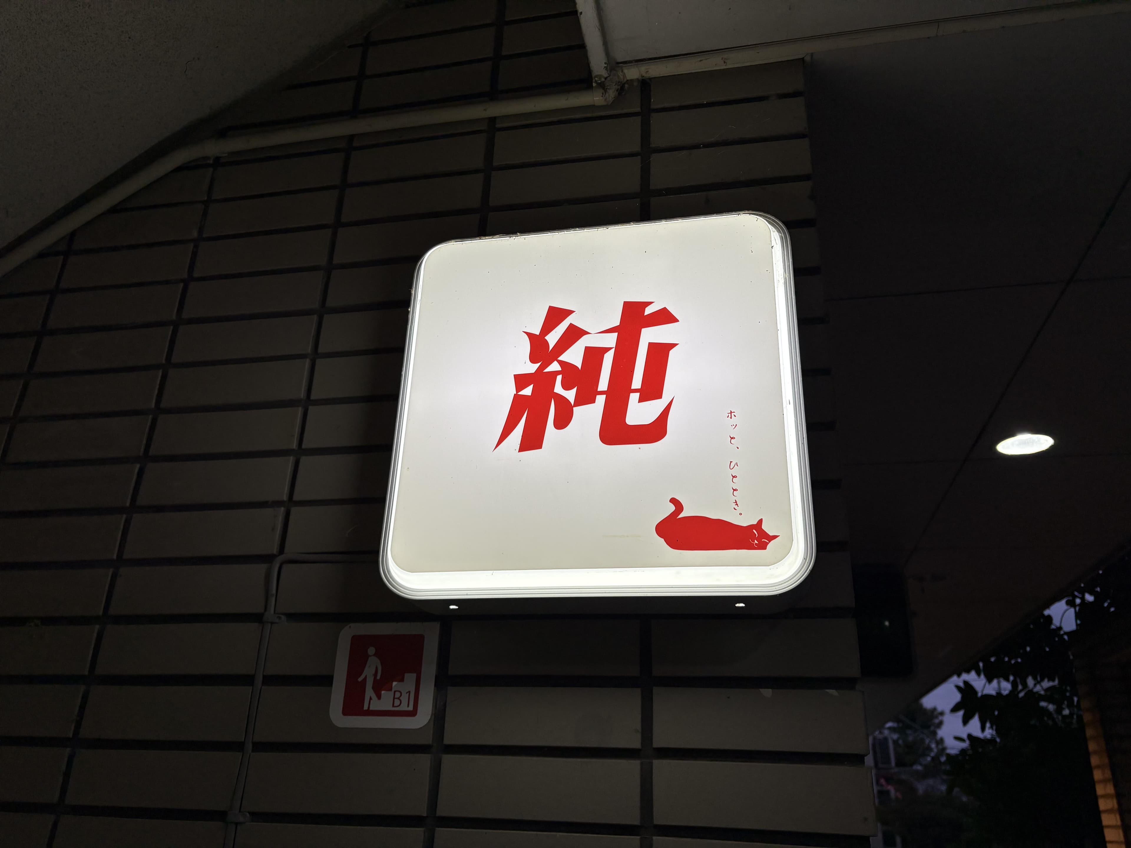 夜に灯る白地の「純」看板