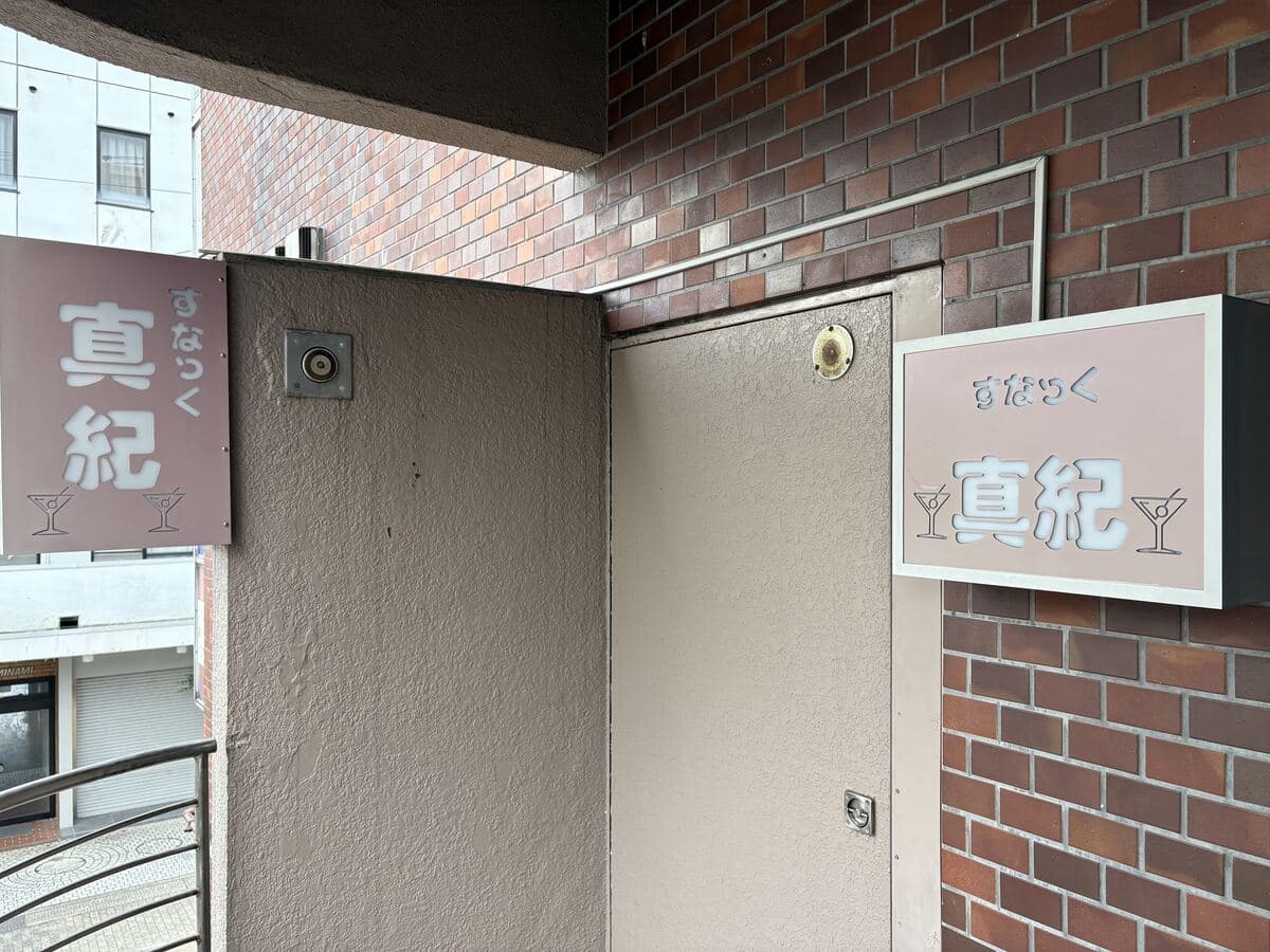 魚津駅前の「真紀」入口脇の白い看板