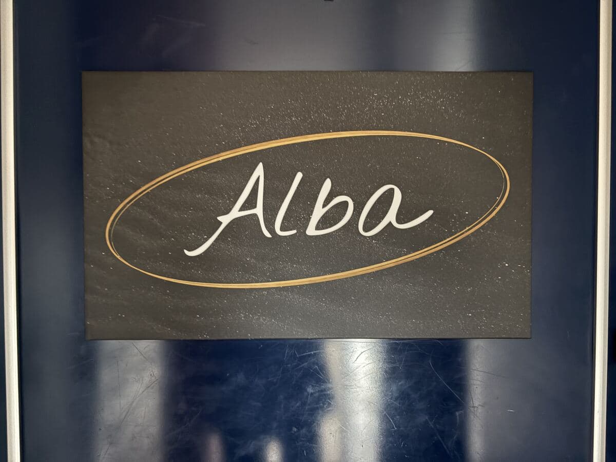 暗色の楕円に金縁の「Alba」