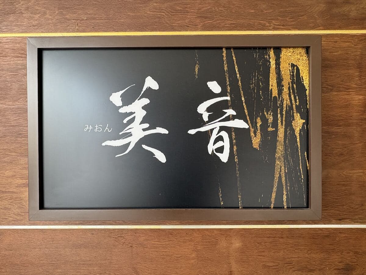 黒地に白い筆文字の「美音」