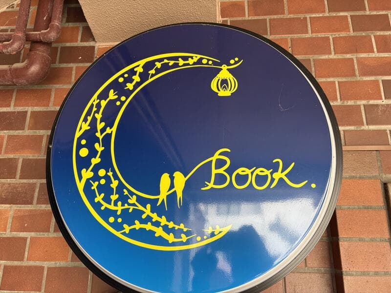 月と鳥を描いた魚津駅前の「Book.」丸看板