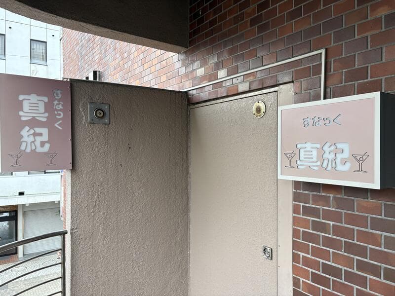 魚津駅前の「真紀」入口脇の白い看板