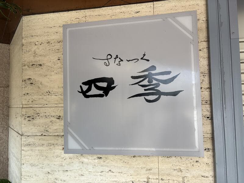 石壁に掛かる「すなっく 四季」の銀色看板