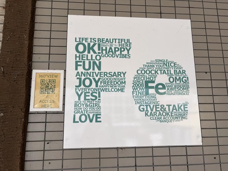 緑の英単語が密集するバーの文字看板Fe