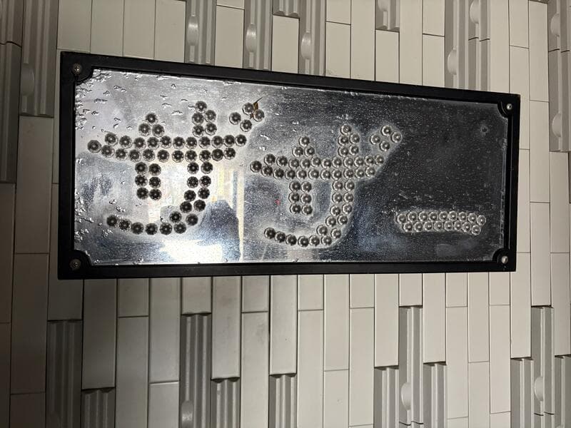 金属の点で文字をつくる魚津駅前の看板