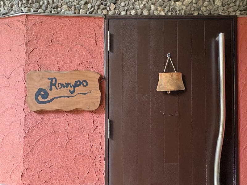 塗り壁に掛かる木製の「Rampo」